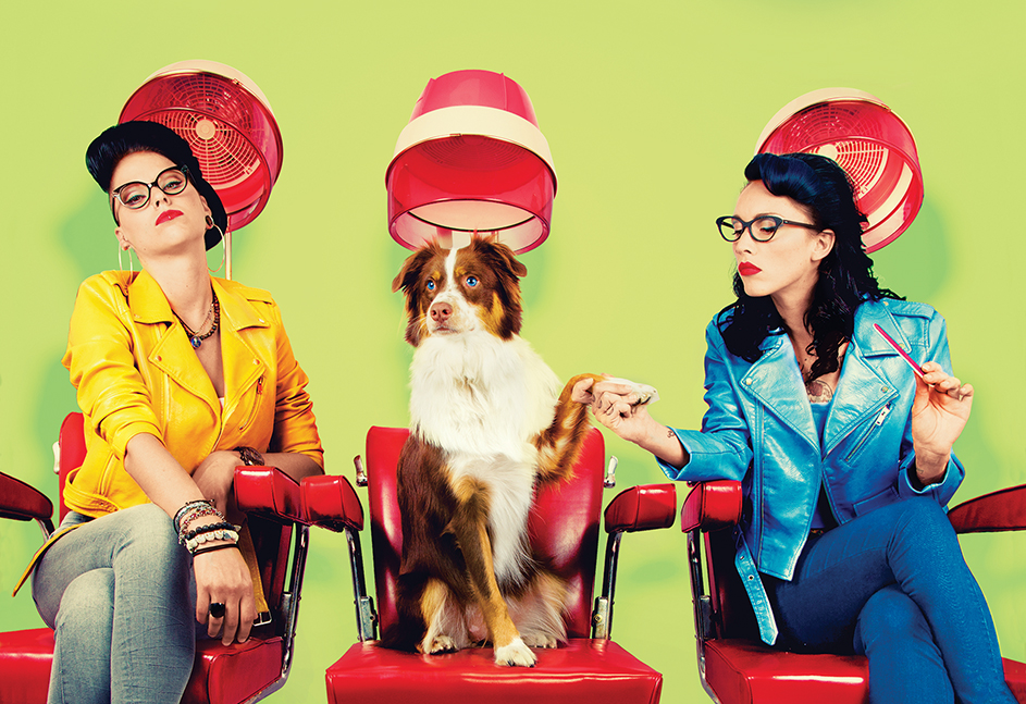 Two women and a dog sitting in hair salon chairs
